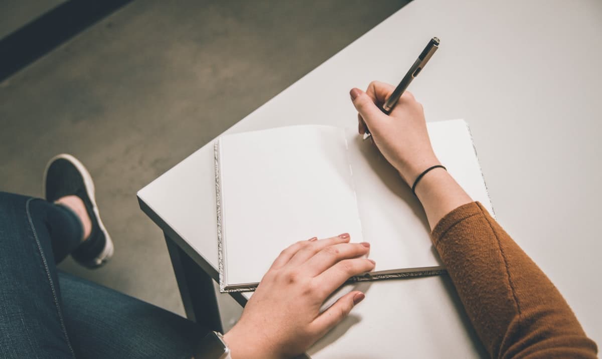 A person writing on a printed page